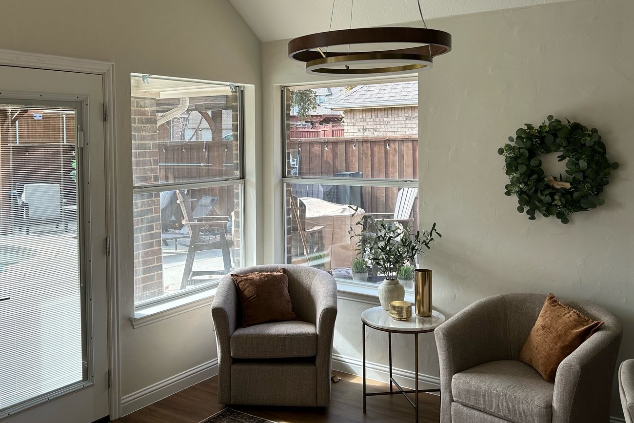 The same living room windows before, with bare glass and glare
