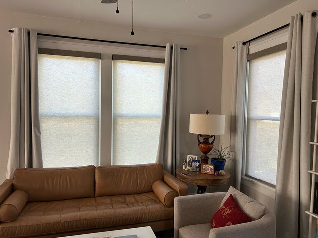 Homeowner retracting a motorized patio shade by remote before a storm
