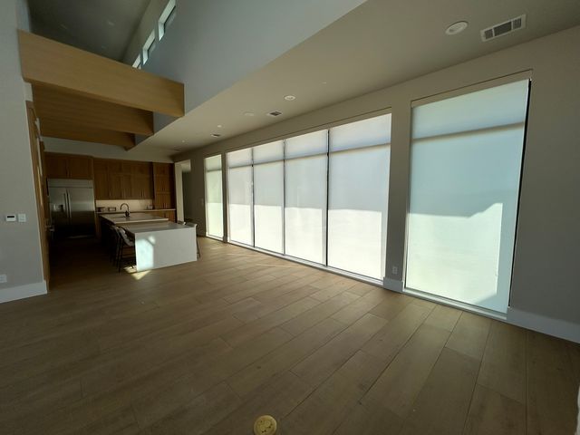 Motorized shade fitted to a tall warehouse style window in a converted loft
