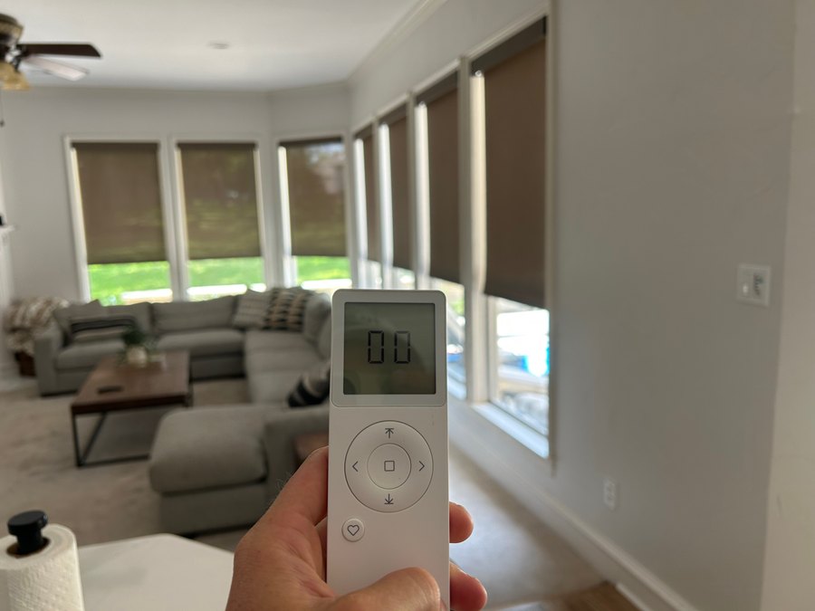 Remote-controlled window shades lowering together on a schedule in a family living room