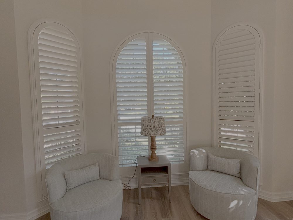 Arched plantation shutters fitted to a specialty-shaped window