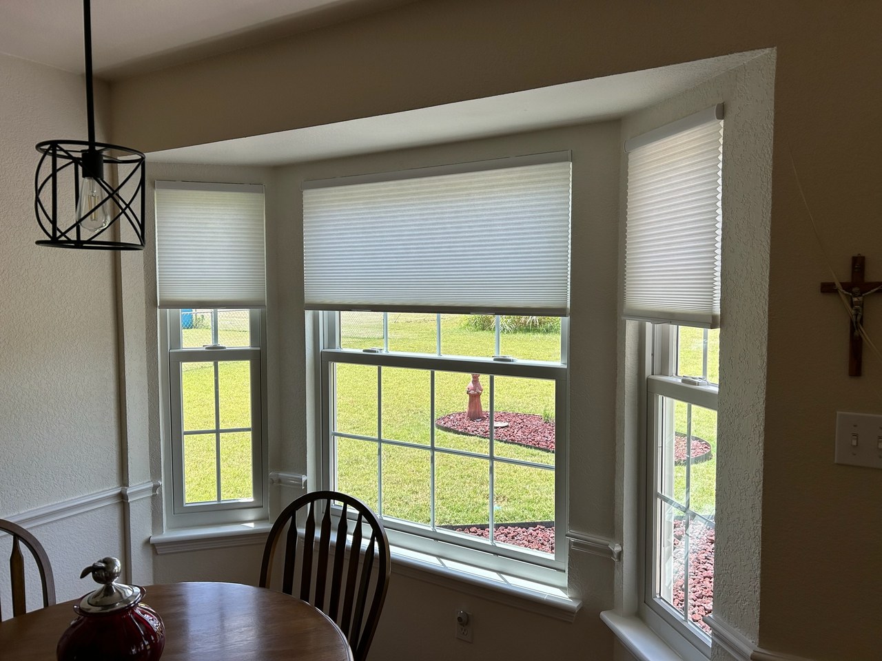 Cellular honeycomb shades on a bay window in a bright Iowa breakfast nook by Love Is Blinds