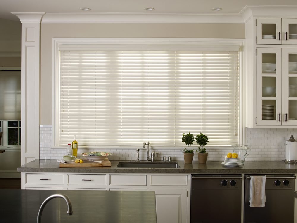 Faux wood blinds in an Iowa kitchen by Love Is Blinds