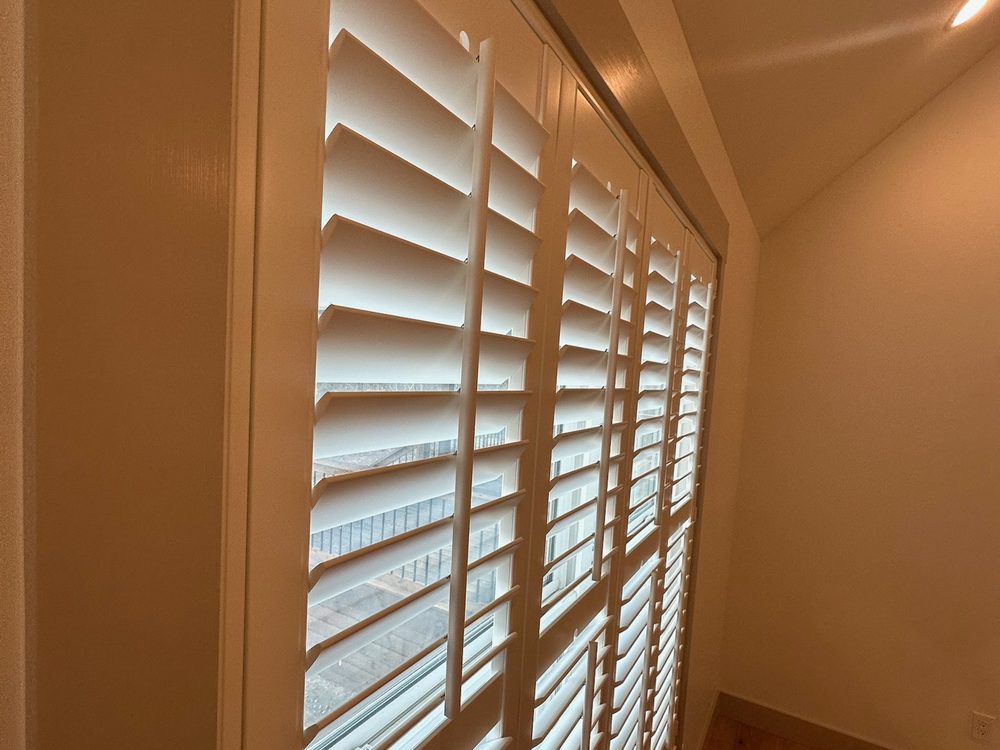 Stained hardwood plantation shutters showing natural grain by Love Is Blinds